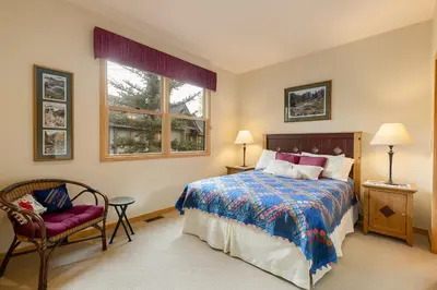 a bedroom with a bed and a chair and a window at 1952 Northstar townhouse in Keystone