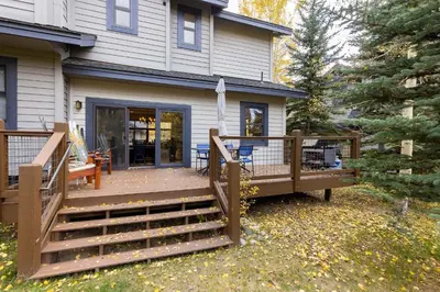 a large wooden deck with stairs leading to a house at 1952 Northstar townhouse in Keystone