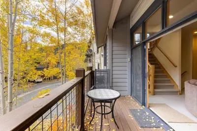 a balcony with a table and a view of trees at 1952 Northstar townhouse in Keystone