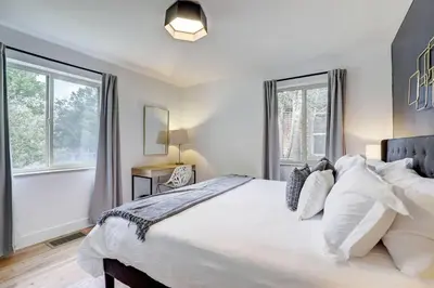 a bedroom with a large white bed and two windows at 3 Min Walk To Olde Town! Hot Tub, Fire Pit, Games! in Arvada