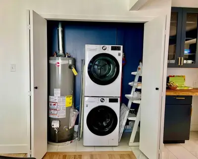 a kitchen with a washing machine and a washer at 3 Min Walk To Olde Town! Hot Tub, Fire Pit, Games! in Arvada