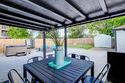 a patio table with chairs and a vase on it at 3 Min Walk To Olde Town! Hot Tub, Fire Pit, Games! in Arvada