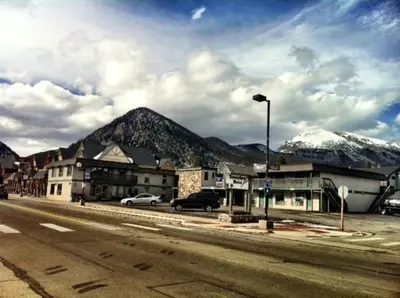 an empty street with snow capped mountains in the background at Snowshoe Motel in Frisco