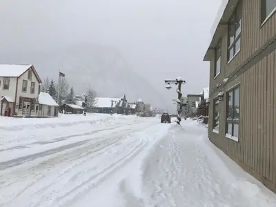 a street covered in snow next to a building at Snowshoe Motel in Frisco