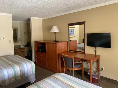 a hotel room with a desk with a television and a bed at Snowshoe Motel in Frisco