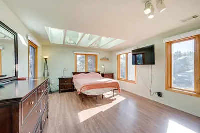 a bedroom with a bed and a flat screen tv at 17 Mi to Town Peaceful Golden Cabin! in Golden