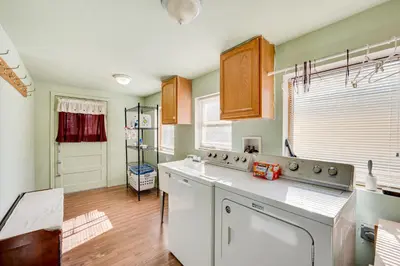 a kitchen with white appliances and wooden floors at 17 Mi to Town Peaceful Golden Cabin! in Golden