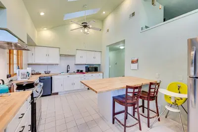 a kitchen with white cabinets and a table and chairs at 17 Mi to Town Peaceful Golden Cabin! in Golden
