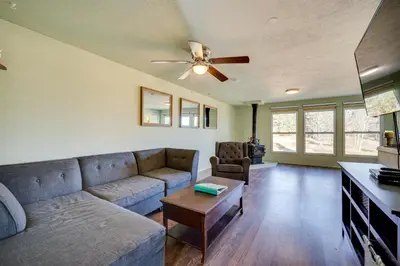a living room with a couch and a ceiling fan at 17 Mi to Town Peaceful Golden Cabin! in Golden