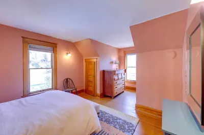 a bedroom with a bed and a dresser and two windows at Home in Downtown Idaho Springs 2022-01 in Idaho Springs