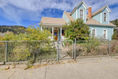 a fence in front of a blue house at Home in Downtown Idaho Springs 2022-01 in Idaho Springs