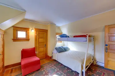 a bedroom with a bunk bed and a red chair at Home in Downtown Idaho Springs 2022-01 in Idaho Springs
