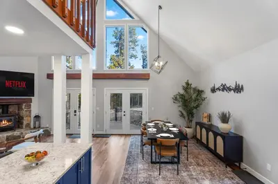 a kitchen and living room with a table and chairs at Cozy A-Frame Retreat - Hot Tub, Forest Views in Black Hawk