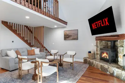 a living room with a couch and a fireplace at Cozy A-Frame Retreat - Hot Tub, Forest Views in Black Hawk