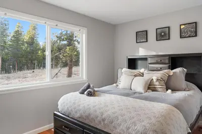 a bedroom with a large bed and a window at Cozy A-Frame Retreat - Hot Tub, Forest Views in Black Hawk