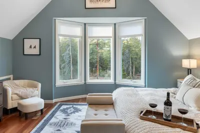 a bedroom with blue walls and windows and a bed at Cozy A-Frame Retreat - Hot Tub, Forest Views in Black Hawk