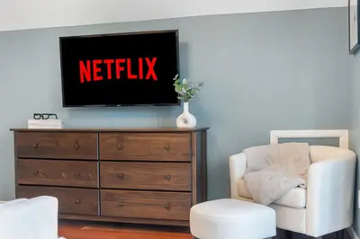 a tv sitting on top of a dresser with a chair at Cozy A-Frame Retreat - Hot Tub, Forest Views in Black Hawk