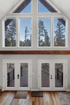 a large room with three doors and windows at Cozy A-Frame Retreat - Hot Tub, Forest Views in Black Hawk