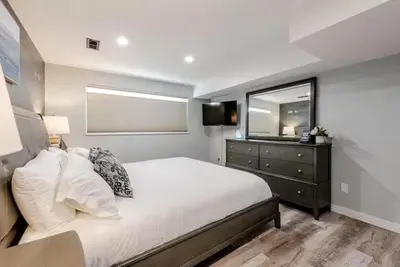 a bedroom with a bed and a dresser with a mirror at 4 Bedrooms and 5 Beds with Game Room Only 5 min Drive to College and Perfect for Family's in Boulder