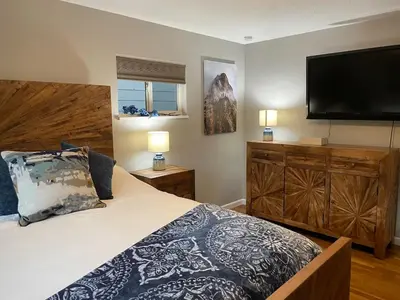 a bedroom with a large bed and a flat screen tv at 4 Bedrooms and 5 Beds with Game Room Only 5 min Drive to College and Perfect for Family's in Boulder