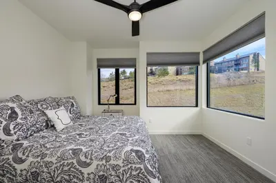 a bedroom with a bed and three windows at Ridgeview at Granby Ranch townhouse in Granby