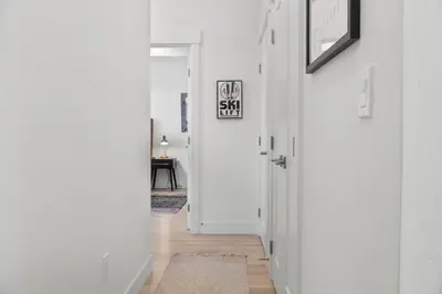 a hallway with white walls and a door with a rug at 2BDR New Build Minutes to Dillon Reservoir in Silverthorne