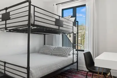 a bedroom with two bunk beds and a chair at 2BDR New Build Minutes to Dillon Reservoir in Silverthorne