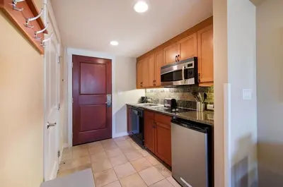 a kitchen with wooden cabinets and a black appliances at Premium Unit 4650- Fraser Crossing Founders Pointe condo in Winter Park