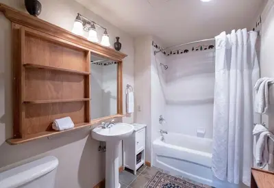 a white bathroom with a sink and a tub and a toilet at Select Unit 1520- 3 Bedroom- Zephyr Mountain Lodge condo in Winter Park
