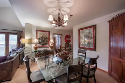 a dining room and living room with a glass table at Select Unit 1520- 3 Bedroom- Zephyr Mountain Lodge condo in Winter Park