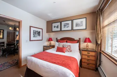 a bedroom with a large bed with a red blanket at Select Unit 1520- 3 Bedroom- Zephyr Mountain Lodge condo in Winter Park