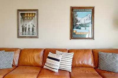 a brown leather couch with two pictures on the wall at Salt Lick Sanctuary in Silverthorne