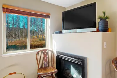 a living room with a fireplace with a flat screen tv at Salt Lick Sanctuary in Silverthorne