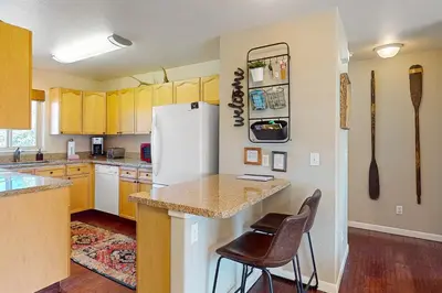 a kitchen with yellow cabinets and a white refrigerator at Salt Lick Sanctuary in Silverthorne