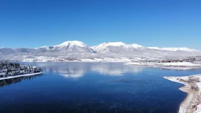 a view of a lake with snow covered mountains at Corinthian Circle - Dillon in Dillon