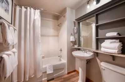 a white bathroom with a sink and a toilet and a tub at Premium Unit 1403 - 2 Bedrooms - Zephyr Mountain condo in Winter Park