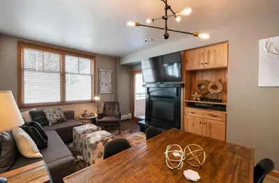 a living room with a table and a fireplace at Premium Unit 1403 - 2 Bedrooms - Zephyr Mountain condo in Winter Park