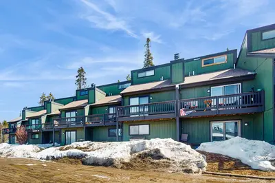 a green building with snow in front of it at Fraser's Mountain Fantasy in Fraser