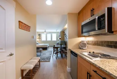 a kitchen with a stove top oven next to a living room at Premium Unit 3522- Fraser Crossing Founders Pointe condo in Winter Park