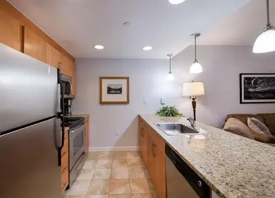 a kitchen with a refrigerator and a sink and a couch at Premium Unit 3513- Fraser Crossing Founders Pointe condo in Winter Park