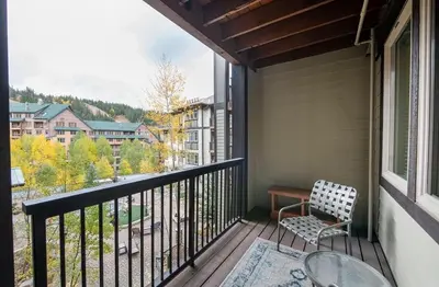 a balcony with a chair and a table and a window at Premium Unit 3513- Fraser Crossing Founders Pointe condo in Winter Park