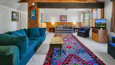 a living room with a blue couch and a rug at Manorhouse Hideaway in Dillon