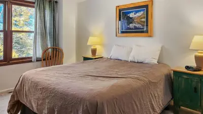 a bedroom with a bed and a chair and a window at Manorhouse Hideaway in Dillon
