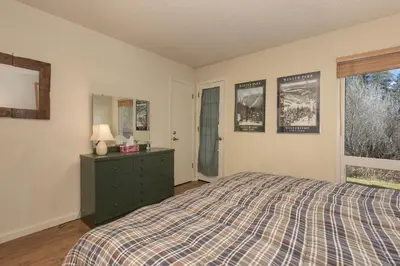 a bedroom with a bed and a dresser and a window at Hi Country Haus Unit 1803 in Winter Park