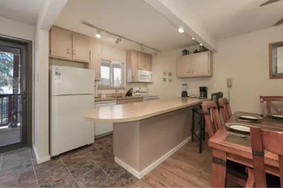 a kitchen with a white refrigerator and a table at Hi Country Haus Unit 1803 in Winter Park
