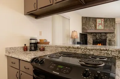 a kitchen with a stove and a fireplace at Meadow Ridge Court 18 Unit 4 in Fraser
