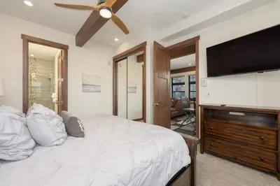 a bedroom with a large bed and a flat screen tv at Arrow at Winter Park Unit 202 in Winter Park