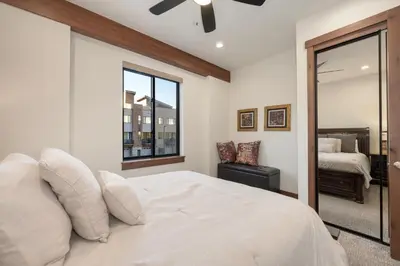 a bedroom with a large white bed and a window at Arrow at Winter Park Unit 202 in Winter Park