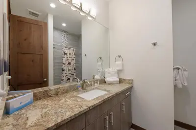 a bathroom with a sink and a large mirror at Arrow at Winter Park Unit 202 in Winter Park