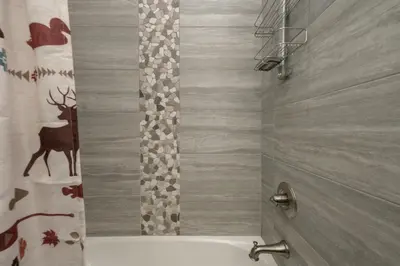a bathroom with a shower with a deer shower curtain at Arrow at Winter Park Unit 202 in Winter Park